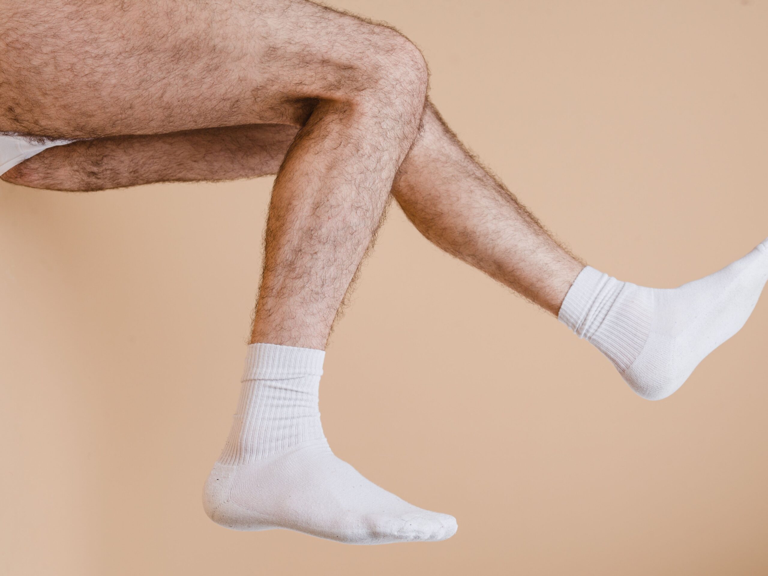 gay male foot fetish with hairy muscle male on horny twink with legs in the air showing off his socks and gay bulge